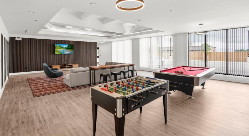 a room with a pool table and chairs