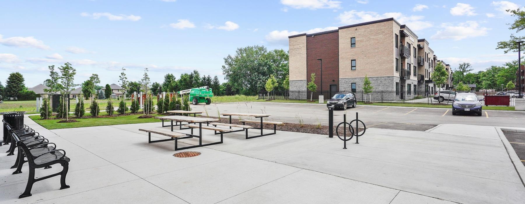 a parking lot with benches and a building in the background